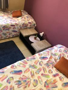 um quarto com 2 camas e uma cama com um edredão em Hospedagem Maria Joana em Atibaia