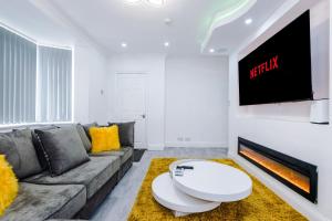 a living room with a couch and a tv at NICE THREE BEDROOM HOUSE in Manchester in Manchester