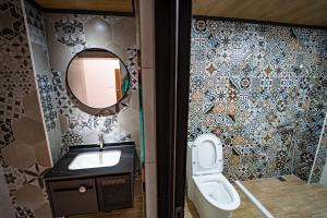 uma casa de banho com um lavatório, um WC e um espelho. em Chen Je B&B em Xiaoliuqiu