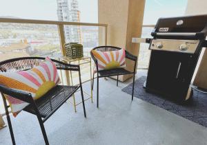 a room with chairs and a stove and a table at DOWNTOWN WATERFRONT KELOWNA OASIS Newly Renovated 2Bed 2Bath in Kelowna