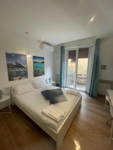 een slaapkamer met een groot bed en een groot raam bij Colombo 32 Affittacamere in La Spezia