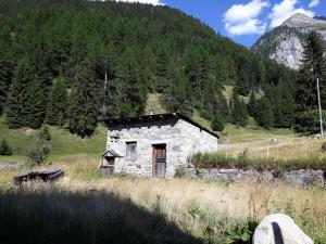 una vieja casa de piedra en medio de un campo en Gasthaus Heiligkreuz, en Binn