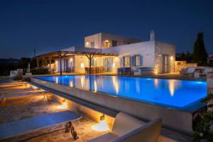 a swimming pool in front of a house at night at Villa Siena in Kampos Paros +23 photos