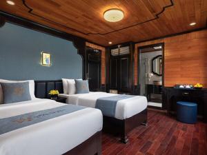 ein Hotelzimmer mit 2 Betten und einem Spiegel in der Unterkunft The Boutique Cruise in Cát Bà