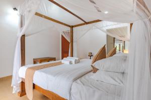 1 dormitorio con 2 camas con sábanas blancas en Villa Mount Melody en Kandy
