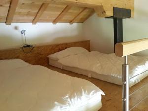 two beds in a room with a loft at Gasthaus Heiligkreuz in Binn