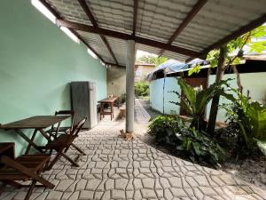 a patio with a wooden table and chairs and a table and a table at Hostel Moreré in Moreré