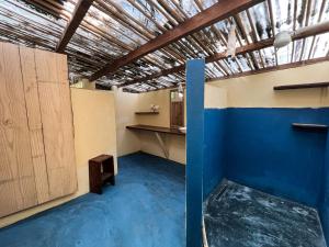 Habitación vacía con suelo azul y armarios de madera. en Hostel Moreré en Moreré
