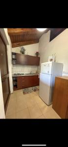 uma cozinha com um frigorífico branco e armários de madeira em Villa Oasi Naturale em Marina di Camerota