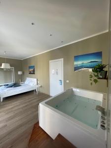 uma grande casa de banho com uma banheira e uma cama em Colombo 32 Affittacamere em La Spezia