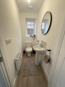 a bathroom with a toilet and a sink and a mirror at The Rita House in Doncaster