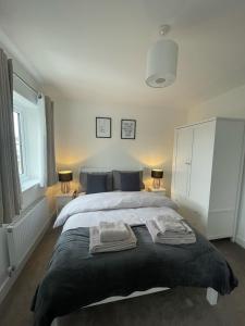 a bedroom with a large bed with towels on it at The Rita House in Doncaster