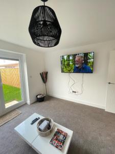 uma sala de estar com televisão na parede em The Rita House em Doncaster