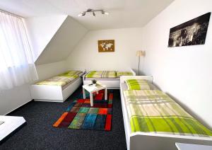 a room with two beds and a table in it at Hotel Uthoff in Bissendorf