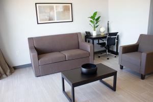 ein Wohnzimmer mit einem Sofa, 2 Stühlen und einem Tisch in der Unterkunft Sun & Sand Resort Oceanfront Suites in Virginia Beach