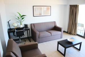 a living room with a couch and a table at Sun & Sand Resort Oceanfront Suites in Virginia Beach