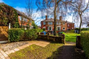 a brick house with a garden in front of it at NICE THREE BEDROOM HOUSE in Manchester in Manchester