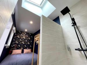 uma casa de banho no sótão com uma cama e um chuveiro em Soleil Levant : calme et terrasse, proche gare em Amiens