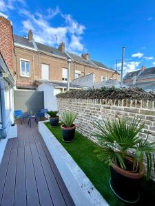 um pátio com vasos de plantas num deque de madeira em Soleil Levant : calme et terrasse, proche gare em Amiens