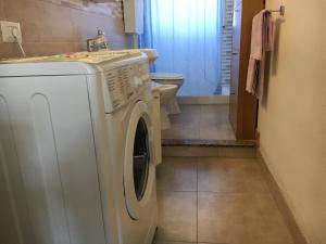a washing machine in a bathroom with a toilet at Venetico Holidays in Spadafora