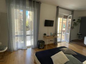 um quarto com uma cama, uma televisão e uma varanda em Colombo 32 Affittacamere em La Spezia