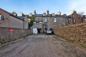 a car parked in front of a brick building at Inviting 9-Bed House in Aberdeen in Aberdeen