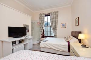 a bedroom with two beds and a flat screen tv at Grand Mansion 9 Beds Sleeps 17 Parking - Groups in Aberdeen