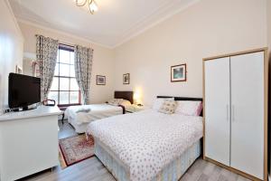 a bedroom with two beds and a flat screen tv at Grand Mansion 9 Beds Sleeps 17 Parking - Groups in Aberdeen