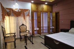 - une chambre avec un lit, une chaise et une fenêtre dans l'établissement Cliff Top View Guest House, à New Mīrpur
