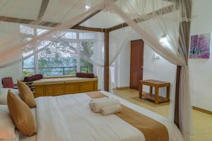 ein Schlafzimmer mit einem Himmelbett und einem Fenster in der Unterkunft Villa Mount Melody in Kandy