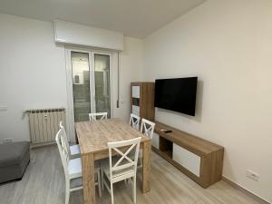 un salon avec une table à manger et une télévision dans l'établissement La casa di Nonno Stefano, à Loano