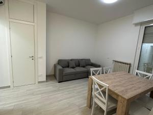 een woonkamer met een bank en een tafel bij La casa di Nonno Stefano - possibilità box privato in Loano