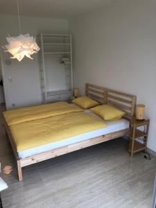 ein Schlafzimmer mit einem großen Bett mit gelber Bettwäsche in der Unterkunft Résidence du Golf Eselborn in Eselborn