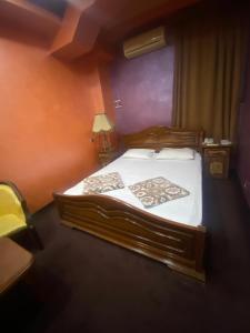 ein Schlafzimmer mit einem großen Holzbett mit weißer Bettwäsche in der Unterkunft HOTEL N1 in Yerevan