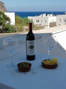 a bottle of wine and two glasses on a table at Apartamento Viento Del Sur in Las Negras