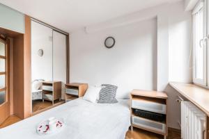 ein kleines Schlafzimmer mit einem Bett und einem Spiegel in der Unterkunft Komfort w samym centrum in Breslau