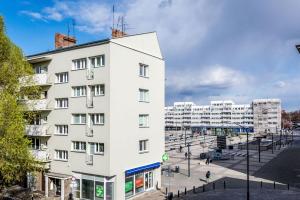 ein weißes Gebäude neben einem Parkplatz in der Unterkunft Komfort w samym centrum in Breslau