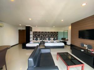 een hotelkamer met 2 bedden en een flatscreen-tv bij Le Vernissage by Goad Avadhess Hospitality in Pattaya