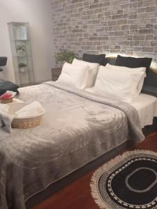 1 cama grande con almohadas blancas y pared de ladrillo en Lovely Cozy Apartment in the entrance of Nicosia en Aglantzia