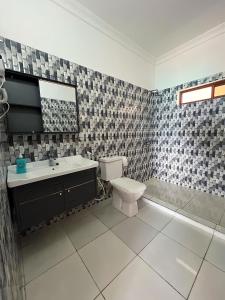 a bathroom with a toilet and a sink and a tub at Zenobia Beach Resort in Nungwi