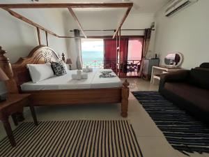 Zenobia Beach Resort في نونغوي: غرفة نوم مع سرير وإطلالة على المحيط