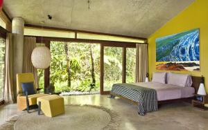 Un dormitorio con una cama y una ventana grande en Umah Tampih Luxury Private Villa - CHSE Certified, en Ubud
