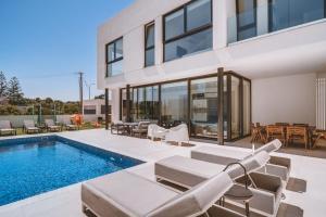 ein Bild von einem Haus mit einem Swimmingpool in der Unterkunft SunnyVillas: 3BR New Villa☆Private Pool in Pernera - White Swan in Protaras