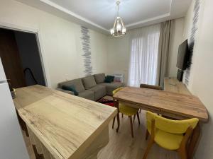 een woonkamer met een tafel en een bank bij Enzo home in Batoemi