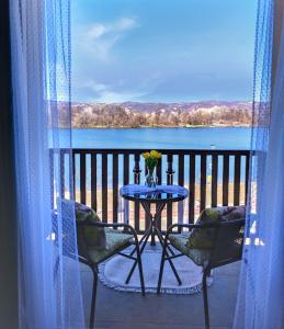 a table and chairs on a balcony with a view of a lake at Adonis in Ostrovo