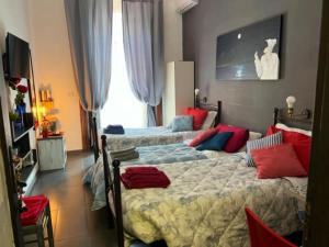 ナポリにあるLa porta accantoのベッドルーム1室(ベッド2台、赤と青の枕付)