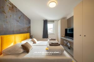 een hotelkamer met 2 bedden en een televisie bij Apartment Panorama Deluxe in Malinska in Malinska