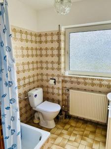 a bathroom with a toilet and a window and a tub at Ferienwohnung in Rheinnähe in Rheinbreitbach