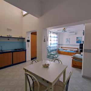 eine Küche und ein Wohnzimmer mit einem Tisch und Stühlen in der Unterkunft Casa Raja in Gaeta