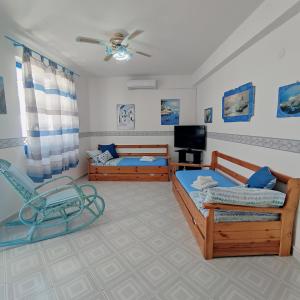 ein Wohnzimmer mit 2 Betten und einem Stuhl in der Unterkunft Casa Raja in Gaeta